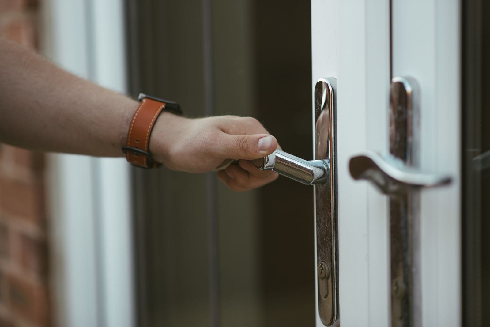 Nahaufnahme einer Hand am Türknauf beim Öffnen der Tür